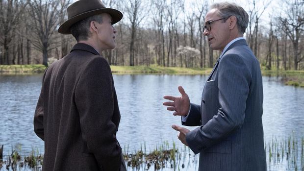 L to R: Cillian Murphy is J. Robert Oppenheimer and Robert Downey Jr is Lewis Strauss in OPPENHEIMER, written, produced, and directed by Christopher Nolan.