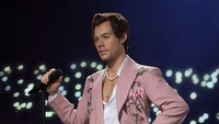 Harry Styles tampil ikonik dengan setelan berwarna pink di tengah penampilannya manggung. Foto: Istimewa