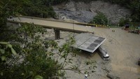 Sebuah truk tertutup lumpur di bawah jembatan yang ambruk saat longsoran maut yang juga melanda beberapa rumah di El Naranjal, Kolombia. Dilansir AFP, Rabu (19/7/2023), longsor ini dipicu akibat hujan lebat.