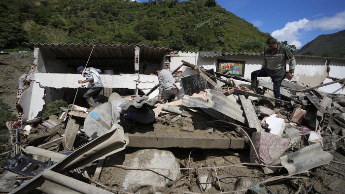 A destroyed car lays in the street after a deadly avalanche smothered homes overnight in El Naranjal, Colombia, Tuesday, July 18, 2023. (AP Photo/Fernando Vergara)