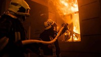 Petugas berusaha memadamkan api di gedung administrasi Odesa yang terbakar akibat serangan rudal Rusia.Press service of the State Emergency Service of Ukraine/Handout via REUTERS.  