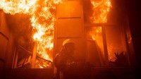 Seorang petugas pemadam kebakaran bekerja di lokasi gedung administrasi yang rusak parah akibat serangan rudal Rusia, di Odesa, Ukraina, 20 Juli 2023. Press service of the State Emergency Service of Ukraine/Handout via REUTERS.  