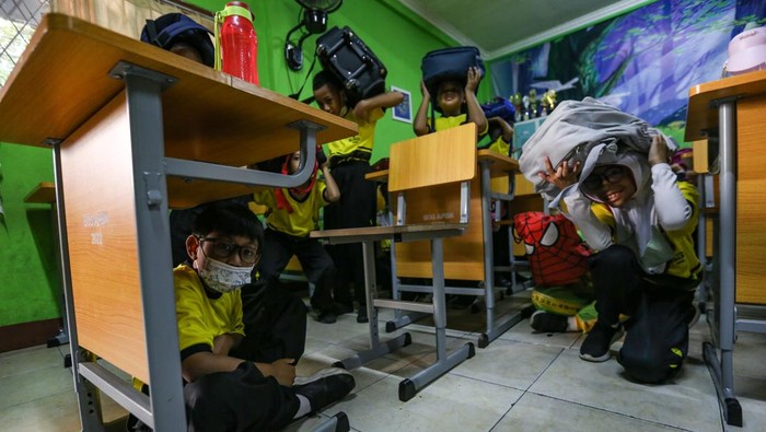 Sejumlah siswa bermain air saat disemprotkan oleh petugas pemadam kebakaran seusai simulasi kesiagaan bencana di SDN Anyelir 1, Depok, Jawa Barat, Kamis (20/7/2023). Kegiatan tersebut untuk mengedukasi dan melatih kesiagaan murid serta guru dalam menghadapi bencana gempa bumi sekaligus mengenalkan profesi pemadam kebakaran.