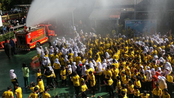 Sejumlah siswa bermain air saat disemprotkan oleh petugas pemadam kebakaran seusai simulasi kesiagaan bencana di SDN Anyelir 1, Depok, Jawa Barat, Kamis (20/7/2023). Kegiatan tersebut untuk mengedukasi dan melatih kesiagaan murid serta guru dalam menghadapi bencana gempa bumi sekaligus mengenalkan profesi pemadam kebakaran.