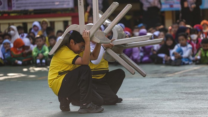 Sejumlah siswa bermain air saat disemprotkan oleh petugas pemadam kebakaran seusai simulasi kesiagaan bencana di SDN Anyelir 1, Depok, Jawa Barat, Kamis (20/7/2023). Kegiatan tersebut untuk mengedukasi dan melatih kesiagaan murid serta guru dalam menghadapi bencana gempa bumi sekaligus mengenalkan profesi pemadam kebakaran.