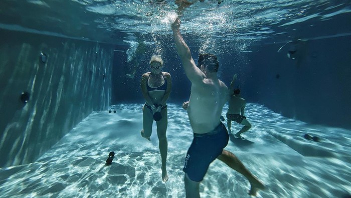 Anggota Gym Pindah Latihan ke Kolam Renang Saat 'Neraka' Bocor di Texas Elizabeth Whitehead and Justin Singer, members of the Mekanix Gym, a total wellness center, use the gym's pool at their Shadow Sanctuary facility to exercise with weights during hot weather in Houston, Texas, U.S., July 19, 2023. REUTERS/Adrees Latif