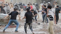 Para pengunjuk rasa bentrok dengan anggota pasukan keamanan ketika mereka berkumpul di dekat kedutaan Swedia di Bagdad, Irak, Kamis (20/7/2023). (REUTERS/Ahmed Saad)    