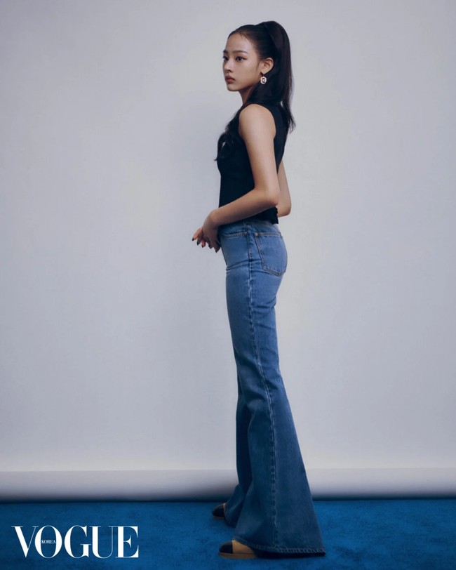 Tak ketinggalan penampilan Minji NewJeans bergaya tahun 70an dengan flared denim pants dan suede boots. Foto: dok. Vogue Korea