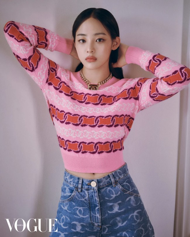 Inilah gaya Minji NewJeans yang familiar bagi penggemar. Pelantun Super Shy itu memakai knit top berwarna pink dengan high-waisted denim berlogo Chanel. Foto: dok. Vogue Korea