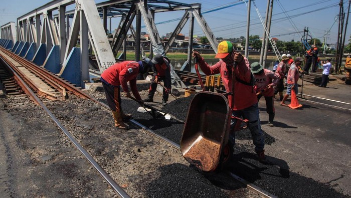 Kemenhub Sarankan Larang Truk Berat Melintas di TKP Kecelakaan KA Brantas Sejumlah pekerja memperbaiki jalur kereta api pasca kecelakaan truk berat tertabrak kereta api di perlintasan Madukoro Raya, Semarang, Jawa Tengah, Jumat (21/7/2023). Dirjen Kementerian Perhubungan menyarankan Pemda setempat memasang rambu larangan kendaraan berat terutama truk trailer berlantai rendah (lowdeck) melintas di perlintasan itu, karena peristiwa kecelakaan KA tabrak truk di lokasi tersebut sudah terjadi tiga kali. ANTARA FOTO/Makna Zaezar/YU