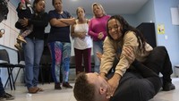 Seorang peserta mendapat pelatihan dari Roberto Camara dalam kursus bela diri di Rio de Janeiro, Brasil, Kamis (20/7/2023).  