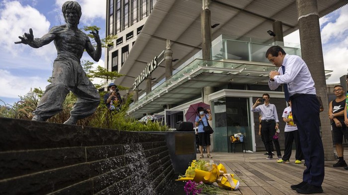 Fans gather in front of the statue of martial artist Bruce Lee to commemorate the 50th anniversary of his death in Hong Kong, Thursday, July 20, 2023. (AP Photo/Louise Delmotte)