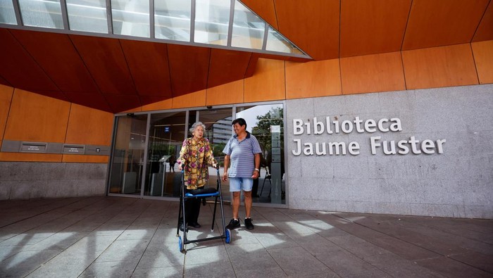 Perpustakaan di Barcelona Jadi Tempat Berlindung Saat Panas Menerjang Barcelona's residents sit in a library, designated as the