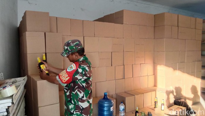 Petugas membongkar gudang miras di Indramayu, Jumat (21/7/2023) malam. Ribuan botol miras disita,
