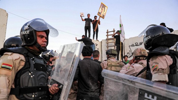 Iraqi riot police try to disperse supporters of Iraqi Shiite cleric Moqtada al-Sadr gathering for a protest outside the Swedish embassy in Baghdad on July 20, 2023. Protesters set fire to Swedens embassy in the Iraqi capital early on July 20 ahead of a planned burning of a Koran in Sweden. Swedish authorities approved an assembly to be held later on July 20 outside the Iraqi embassy in Stockholm, where organisers plan to burn a copy of the Koran as well as an Iraqi flag. (Photo by Ahmad AL-RUBAYE / AFP)