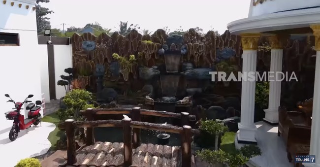 Halaman rumah juga dimanfaatkan sebagai taman lengkap dengan kolam dan gazebo. (Foto: YouTube/Trans7 Official)