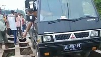 Sebuah mobil melintasi jembatan darurat di Sergai. Jembatan ini menjadi jalur alternatif  penghubung Sergai dan Batu Bara. (Foto: Istimewa)