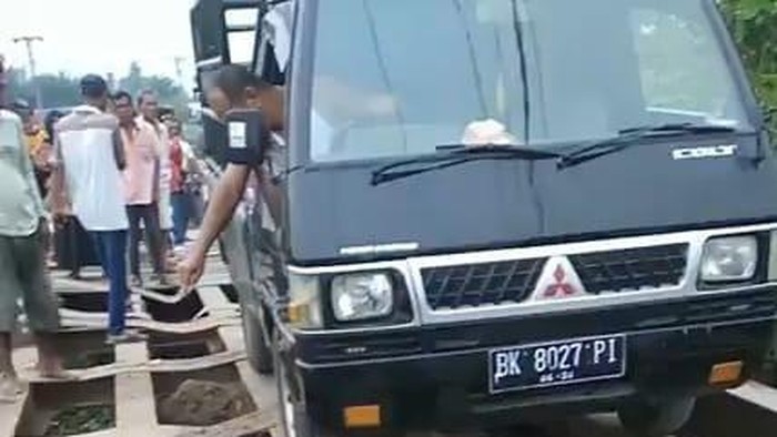 Sebuah mobil melintasi jembatan darurat di Sergai (Foto: Istimewa)