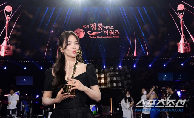 Song Hye Kyo naik ke atas panggung Blue Dragon Awards 2023 saat namanya disebut sebagai pemenang Daesang atau grand prize. Hye Kyo menang Daesang atas aktingnya yang berkualitas di drama Korea The Glory. Foto: Dok. imbc, sportschosun, Instagram Song Hye Kyo