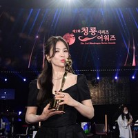 Song Hye Kyo naik ke atas panggung Blue Dragon Awards 2023 saat namanya disebut sebagai pemenang Daesang atau grand prize. Hye Kyo menang Daesang atas aktingnya yang berkualitas di drama Korea The Glory. Foto: Dok. imbc, sportschosun, Instagram Song Hye Kyo