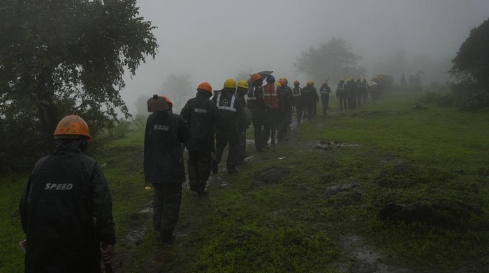 Rescuers work at a site of a landslide triggered by torrential rains in Raigad district, western Maharashtra state, India, Thursday, July 20, 2023. While some people are reported dead many others feared trapped under piles of debris. (AP Photo/Rafiq Maqbool)