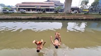 Meski berbahaya, mereka tetap asyik bermain di sungai tersebut. 