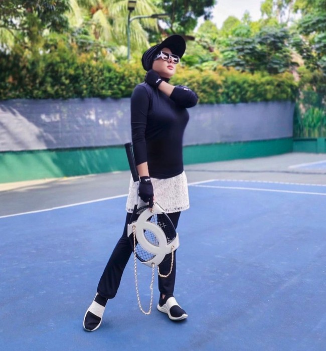 Pilihan padu padan baju olahraga hitam juga bisa membantu menyamarkan siluet tubuh. Kini ia melapisi leggingnya dengan rok brokat yang mencuri atensi. Foto: Instagram @princessyahrini