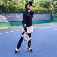 Pilihan padu padan baju olahraga hitam juga bisa membantu menyamarkan siluet tubuh. Kini ia melapisi leggingnya dengan rok brokat yang mencuri atensi. Foto: Instagram @princessyahrini