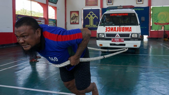 Seorang warga binaan menarik mobil ambulance menggunakan tali tambang saat mengikuti perlombaan di Lapas Kelas IIB, Kabupaten Batang, Jawa Tengah, Sabtu, (22/7/2023). Selain dalam rangka rangkaian peringatan Hari Kemenkumham ke-78, lomba tarik mobil ambulance seberat 2,3 ton dan lintasan sepanjang 20 meter itu diikuti oleh 16 warga binaan pemasyarakatan untuk menjaga kebugaran agar tetap sehat secara jasmani. ANTARA FOTO/Harviyan Perdana Putra/hp.