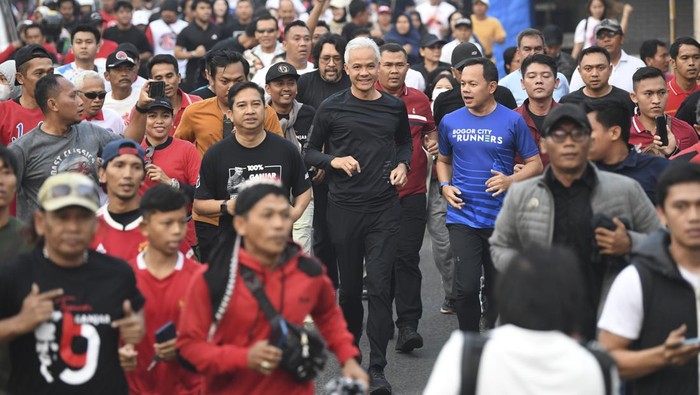 Momen Ganjar Bareng Gibran & Walkot Bogor Blusukan ke Pasar Citeureup Bakal calon presiden (Bacapres) dari PDI Perjuangan Ganjar Pranowo (tengah kiri) didampingi Wali Kota Bogor, Bima Aya (tengah kanan) berlari saat melakukan safari politik di Citeureup, Kabupaten Bogor, Jawa Barat, Sabtu (22/7/2023). Dalam kesempatan tersebut Ganjar Pranowo berlari bersama warga dan relawan hingga blusukan ke pasar untuk mengetahui harga bahan pokok dan bertemu dengan sejumlah Gen Z. ANTARA FOTO/M Risyal Hidayat/hp.