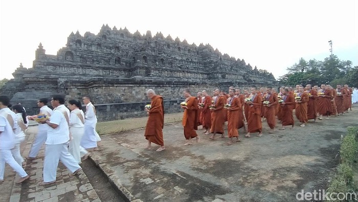 Umat Buddha melakukan prosesi pradaksina atau mengelilingi Candi Borobudur, Sabtu (22/7/2023).