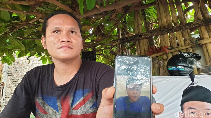 Berto Siagian saat menunjukkan foto Yosua Samosir sewaktu hidup di rumah duka, Jalan Karya Bakti, Kota Medan. (Goklas Wisely/detikSumut)