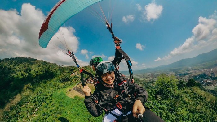 Bupati Ipuk Fiestiandani menikmati pemandangan Banyuwangi dari ketinggian saat naik paralayang.