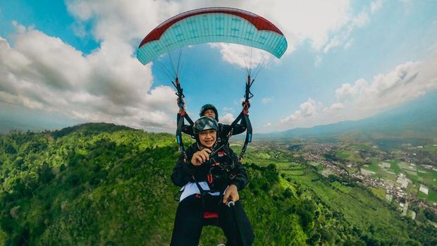 Bupati Ipuk Fiestiandani menikmati pemandangan Banyuwangi dari ketinggian saat naik paralayang.