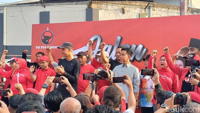 Ganjar Pranowo dan Gibran Rakabuming Raka saat menghadiri gerak jalan sehat di Kelurahan Pucangsawit, Kecamatan Jebres, Kota Solo, Minggu (23/7/2023).