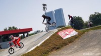 Para atlet saling beradu cepat melintasi track BMX.