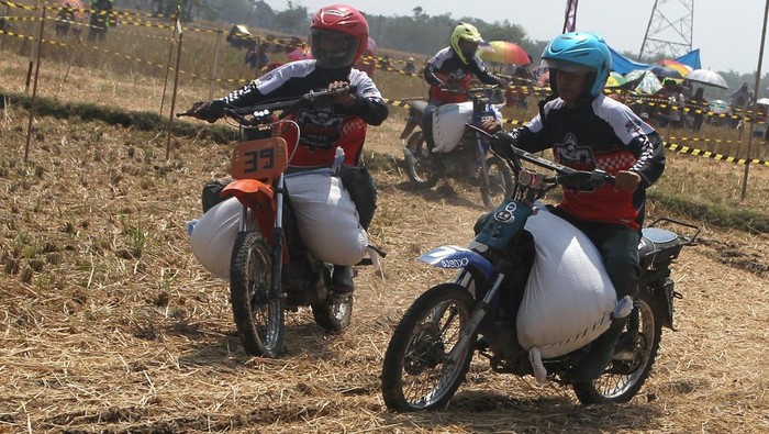Peserta berusaha memacu motornya saat mengikuti Grasstrack Ojek Pengangkut Gabah di area persawahan desa Mangunharjo, Ngawi, Jawa Timur, Minggu (23/7/2023). Lomba tersebut diadakan sebagai bentuk apresiasi terhadap para pengendara ojek pengangkut gabah yang telah membantu petani sekaligus sebagai ungkapan syukur kepada Tuhan atas hasil panen yang berlimpah pada musim panen kedua di tahun 2023. ANTARA FOTO/Ari Bowo Sucipto/YU