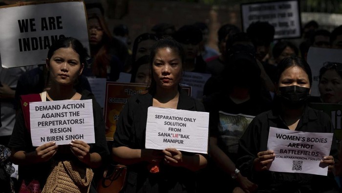 Para demonstran di India menuntut mundurnya pejabat tinggi Manipur, yang menjadi lokasi dua wanita diarak bugil dan diperkosa massal saat konflik antaretnis marak pada awal Mei lalu. (AP Photo/Altaf Qadri)