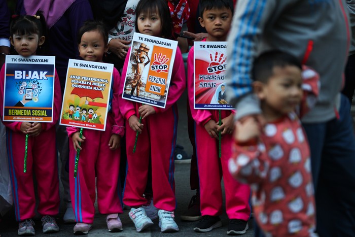 Sejumlah anak membentangkan poster saat memperingati Hari Anak Nasional pada Hari Bebas Kendaraan Bermotor atau Car Free Day di Jalan Darmo, Surabaya, Jawa Timur, Minggu (23/7/2023). Kegiatan yang diikuti ratusan pelajar sekota Surabaya guna menyerukan berbagai aspirasi diantaranya stop kekerasan pada anak, stop perkawinan usia dini dan stop mempekerjakan anak. ANTARA FOTO/Didik Suhartono/YU