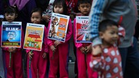 Sejumlah anak membentangkan poster saat memperingati Hari Anak Nasional pada Hari Bebas Kendaraan Bermotor atau Car Free Day di Jalan Darmo, Surabaya, Jawa Timur, Minggu (23/7/2023). ANTARA FOTO/Didik Suhartono