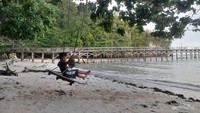 Seorang anak bermain ayunan di Pantai Putras, Raja Ampat.
