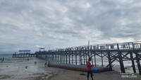 Jembatan menjulur ke laut menjadi tempat pemotreran di Pantai Putras, Raja Ampat