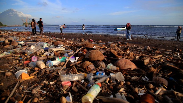 Wisata Pantai Kastela Ternate Dipenuhi Sampah Kiriman Pengunjung menikmati suasana pantai di dekat sampah yang berserakan di Pantai Kastela, Kota Ternate, Maluku Utara, Minggu (23/7/2023). Sampah kiriman yang terdampar dan mencemari kawasan wisata pantai tersebut karena terbawa gelombang laut dan angin kencang yang terjadi beberapa hari terakhir.ANTARA FOTO/Andri Saputra/nz.