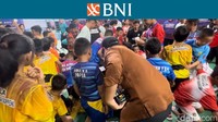 Bupati Gowa Adnan Purichta Ichsan menyemarakkan pembukaan BNI Sirnas B Sulses 2023 ini dengan memukul shuttlecock yang diselipkan uang pecahan Rp 100 ribu. Para peserta pun ramai-ramai berusaha mengambilnya. Foto: Mercy Raya/detikcom 