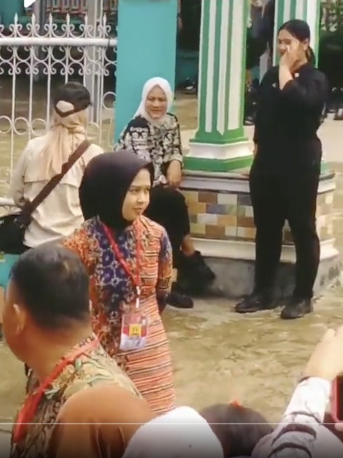 Ibu Negara, Iriana, menunggu di gerbang masjid saat Jokowi salat Jumat di Bengkulu Utara.