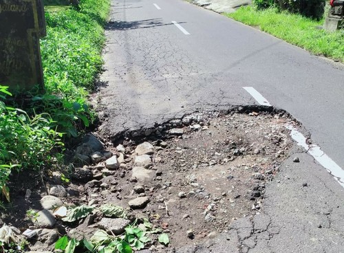 Jalan jalur Banjarangkan Klungkung mengalami kerusakan di sejumlah titik, mengakibatkan bahaya bagi pengendara, Minggu (23/7/2023). (Putu Krista/detikBali)