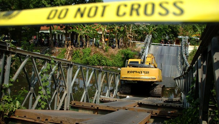Alat berat berada di tengah jembatan Kali Kemiri yang ambruk di Desa Kupu, Kabupaten Tegal, Jawa Tengah, Senin (24/7/2023). Jembatan bailey (darurat) dengan panjang 27 meter dan lebar 5 meter yang menjadi jembatan sementara penghubung Desa Kupu Kabupaten Tegal dan Desa Jatibarang Brebes tersebut ambruk akibat dilewati alat berat. ANTARA FOTO/Oky Lukmansyah/tom.