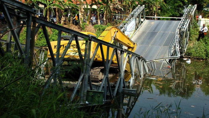 Jembatan Darurat di Tegal Ambruk Gegara Dilewati Alat Berat Alat berat berada di tengah jembatan Kali Kemiri yang ambruk di Desa Kupu, Kabupaten Tegal, Jawa Tengah, Senin (24/7/2023). Jembatan bailey (darurat) dengan panjang 27 meter dan lebar 5 meter yang menjadi jembatan sementara penghubung Desa Kupu Kabupaten Tegal dan Desa Jatibarang Brebes tersebut ambruk akibat dilewati alat berat. ANTARA FOTO/Oky Lukmansyah/tom.