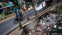 Sampah menumpuk di selokan depan kantor Kelurahan Pondok Aren, Jalan Raya Pondok Aren, Tangsel, Senin (23/7/2023).