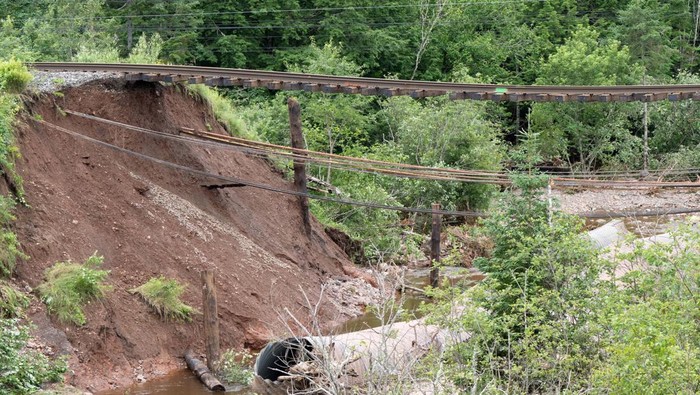 People embrace as they stand near damage to a road, after the heaviest rain to hit the Atlantic Canadian province of Nova Scotia in more than 50 years triggered floods, in Ellershouse, West Hants Regional Municipality, Nova Scotia, Canada July 23, 2023. REUTERS/John Morris